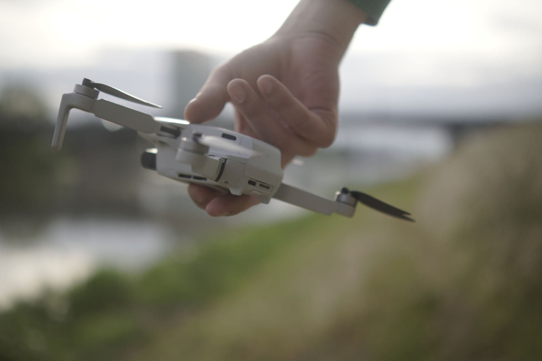 Palm-sized drone hovering in front of a hiker on a mountain trail