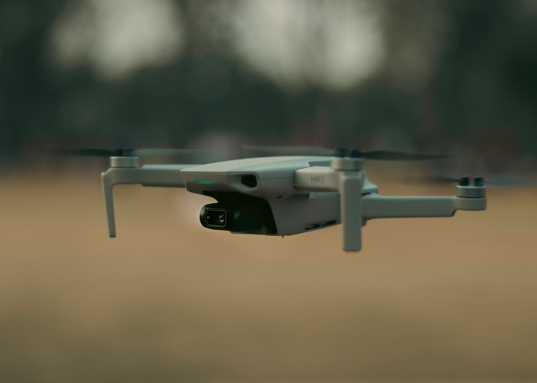 DJI Mini 5 Pro drone flying with camera gimbal visible at sunset