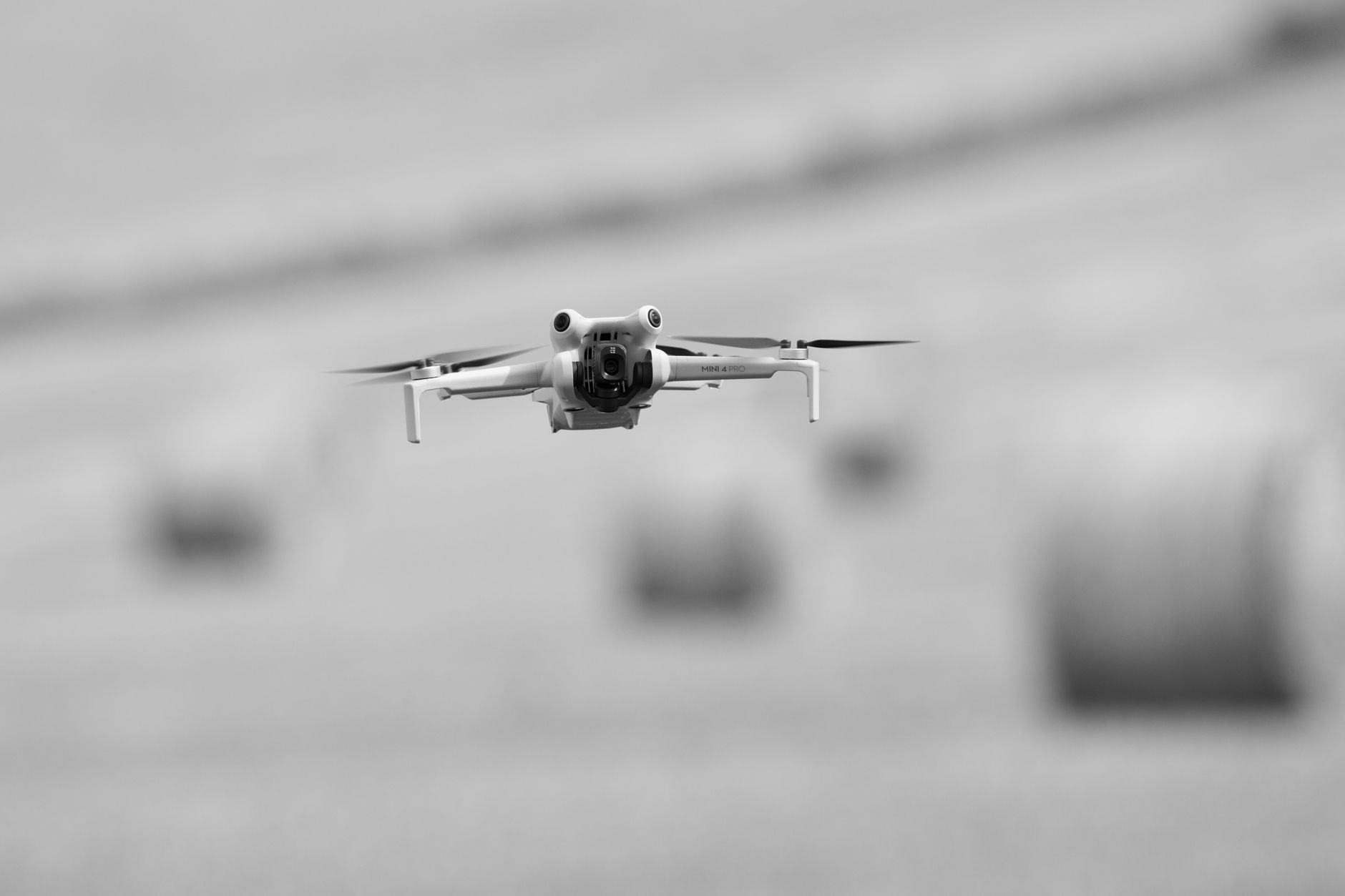 DJI Mini 4K drone hovering above grass field