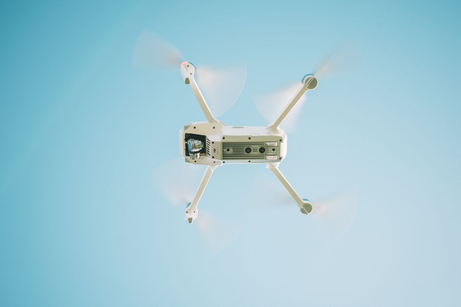 Small white toy drone hovering in a living room